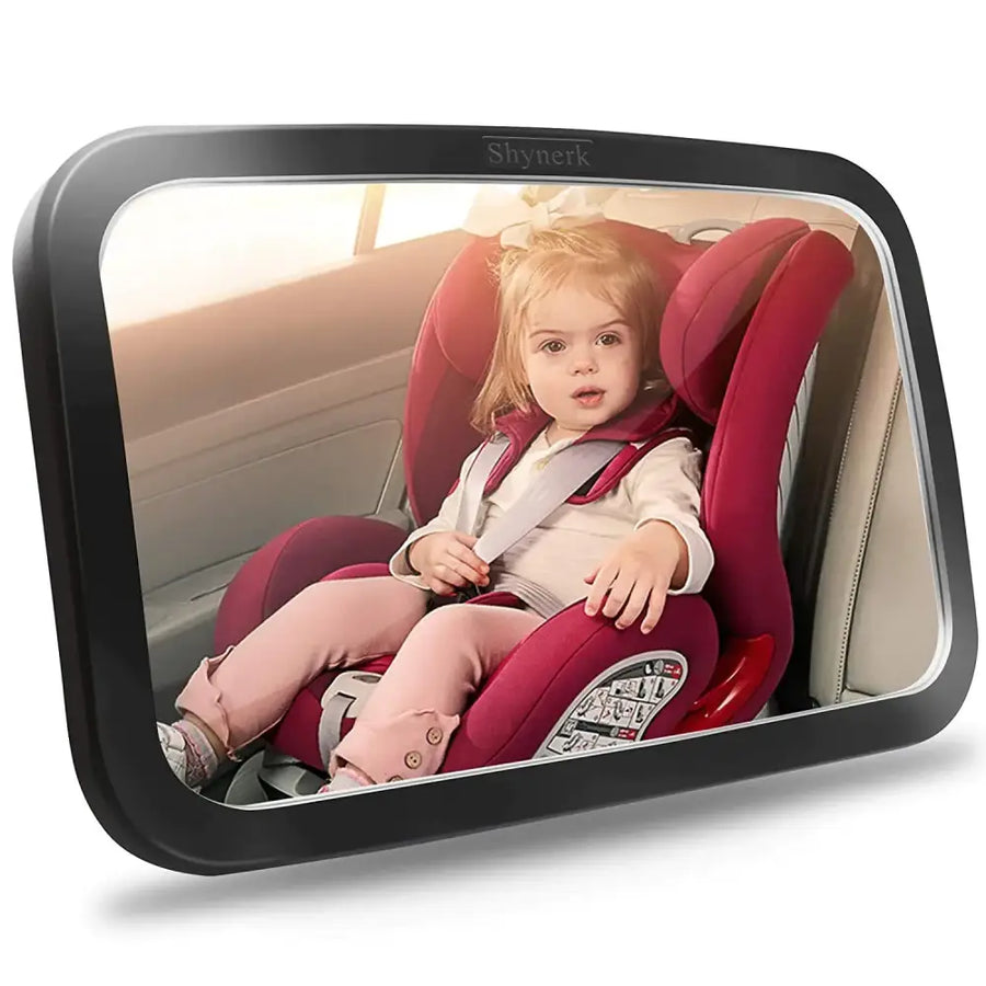 Black-framed rearview mirror displaying a child in a red car seat.