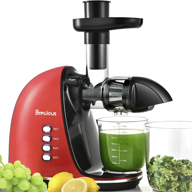 Red and black brecious slow juicer with a clear juice collection cup filled with green liquid.