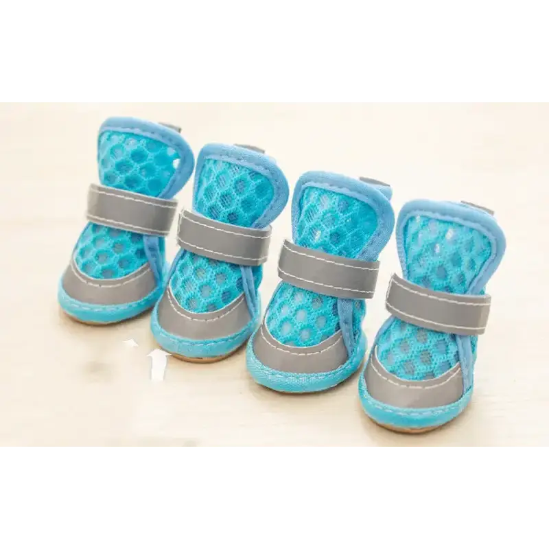 Light blue mesh dog booties with gray velcro straps and stitched edges.