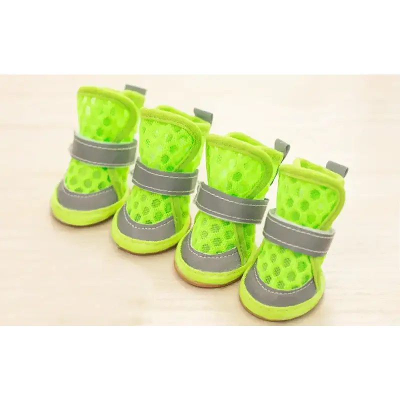 Bright neon green mesh dog boots with gray reflective straps and rubber soles.