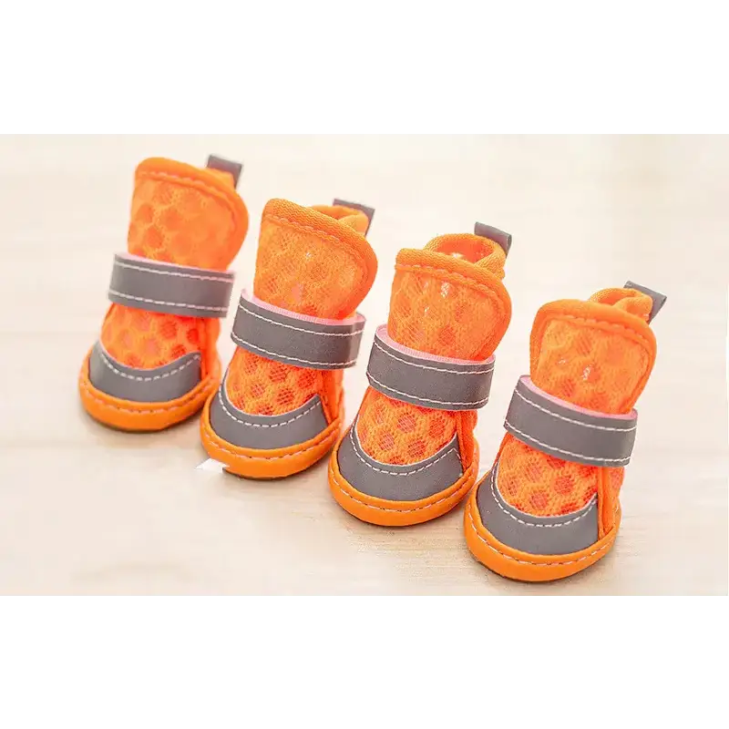 Bright orange mesh dog boots with gray reflective straps and stitched detailing.
