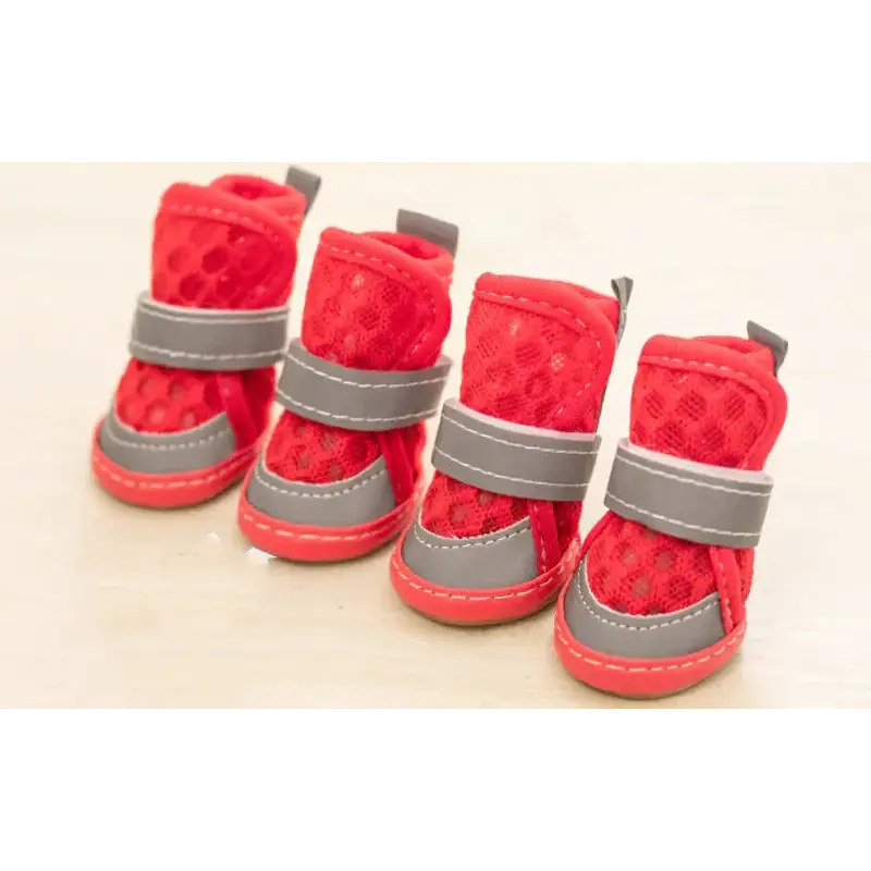 Red mesh dog boots with gray velcro straps and rubber soles.