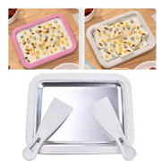 Silver rectangular ice cream making tray with two white plastic spatulas