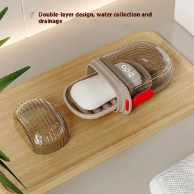 Transparent and beige plastic soap dish with a double-layer design, featuring water collection and drainage functionality.