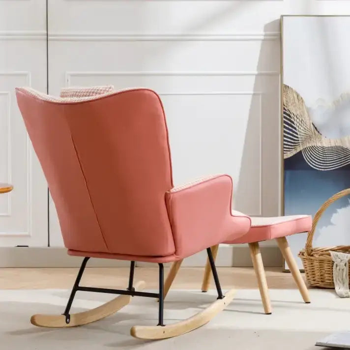 A coral-colored upholstered rocking chair with a matching footstool, featuring wooden rockers and black metal legs.