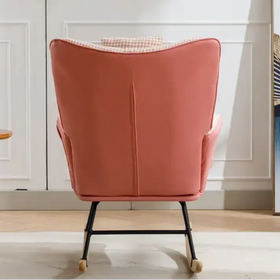 A coral-pink upholstered rocking chair with a houndstooth-patterned cushion and black metal frame.