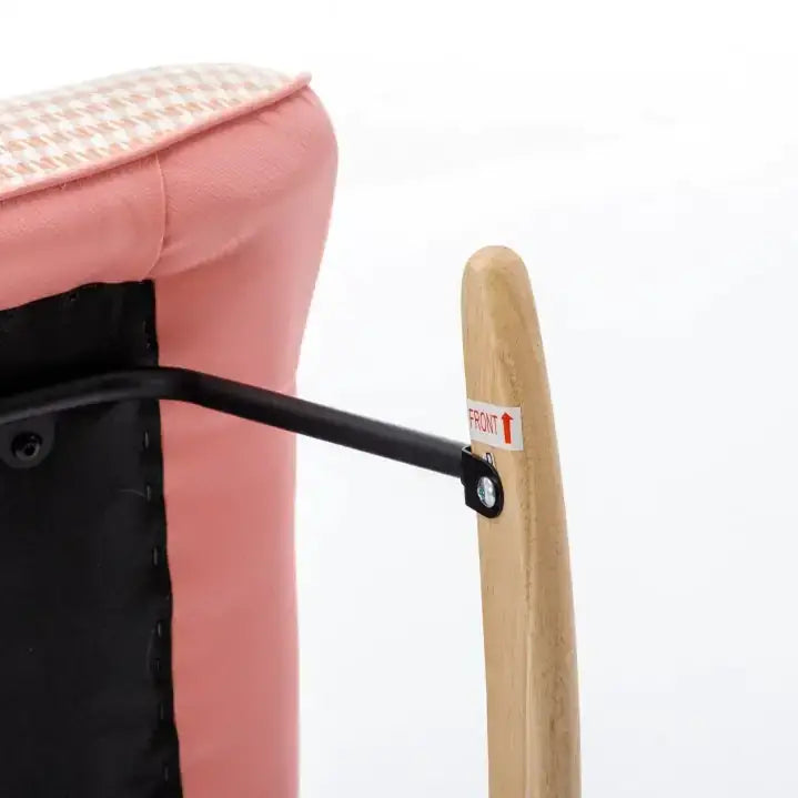Pink upholstered chair armrest with a light wood frame and black metal support bracket.