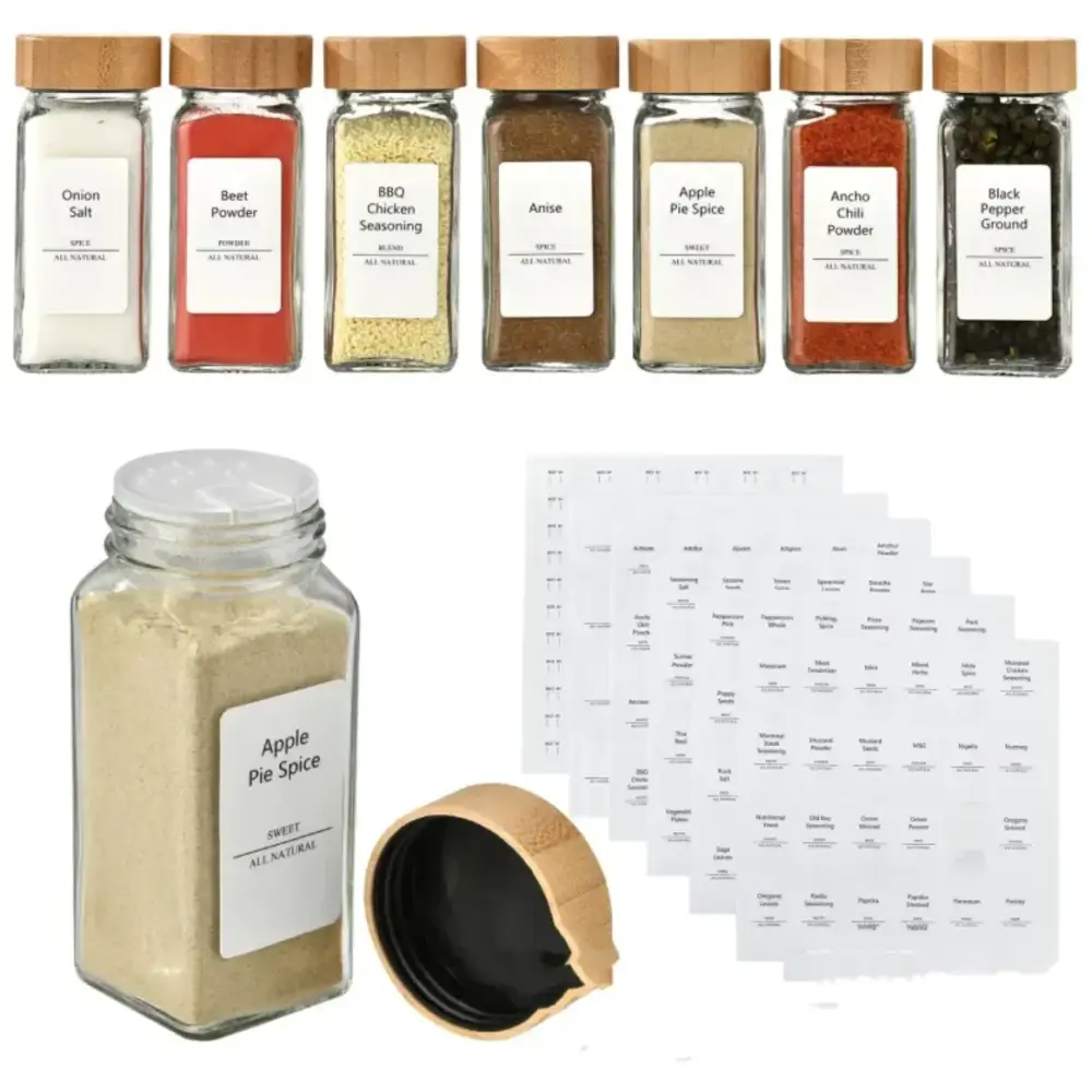 Clear glass spice jar with a wooden lid and white label reading ’apple pie spice’ containing light brown powder.