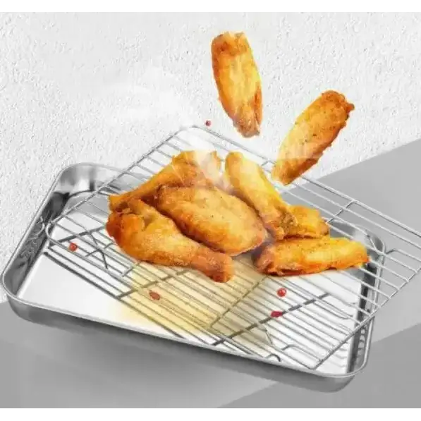 Shiny stainless steel baking tray with a wire rack placed on top, holding golden-brown fried chicken pieces.