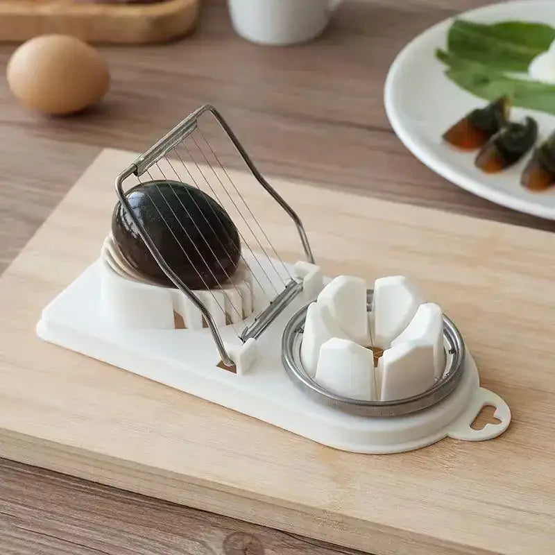 White plastic and stainless steel egg slicer with a blackened duck egg positioned on its wire grid.