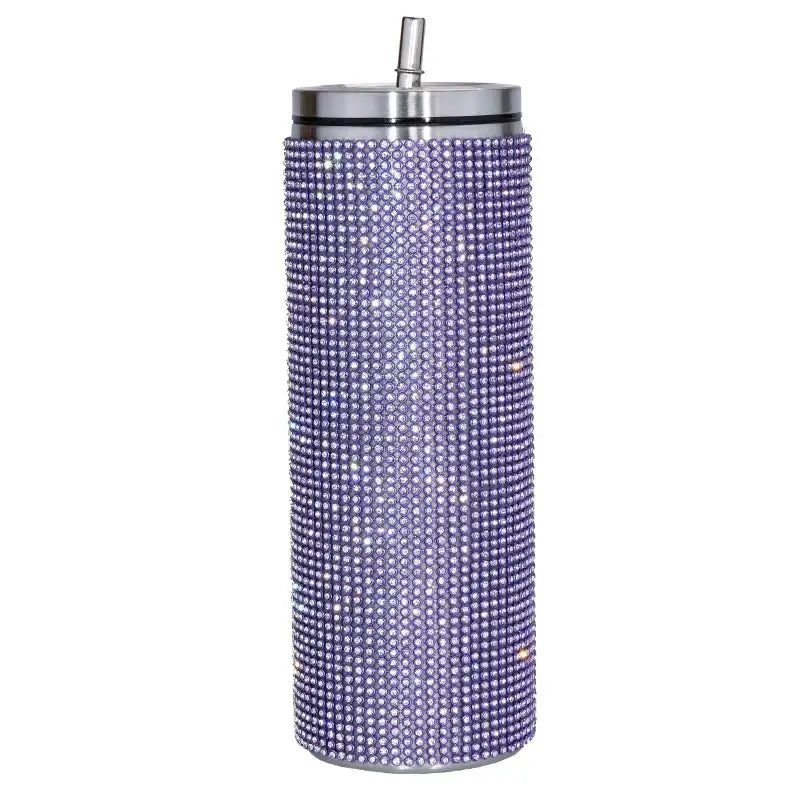 A sparkling purple insulated tumbler adorned with a dense pattern of clear rhinestones and featuring a silver lid and straw.