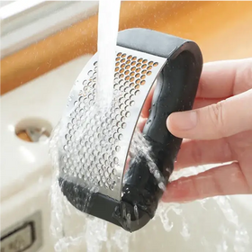 Black and stainless steel garlic press with a honeycomb patterned grating surface.