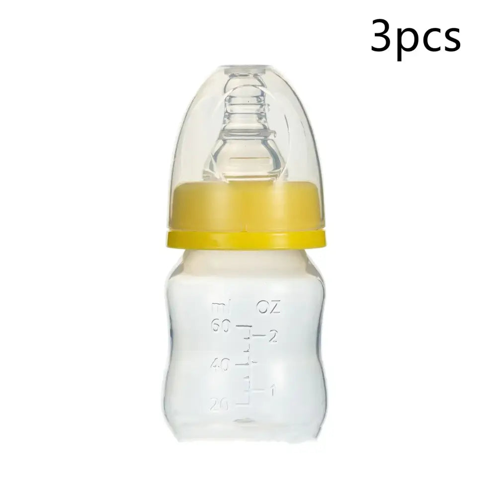 Clear glass baby bottle with a yellow plastic ring and transparent nipple, marked with ounce measurements.
