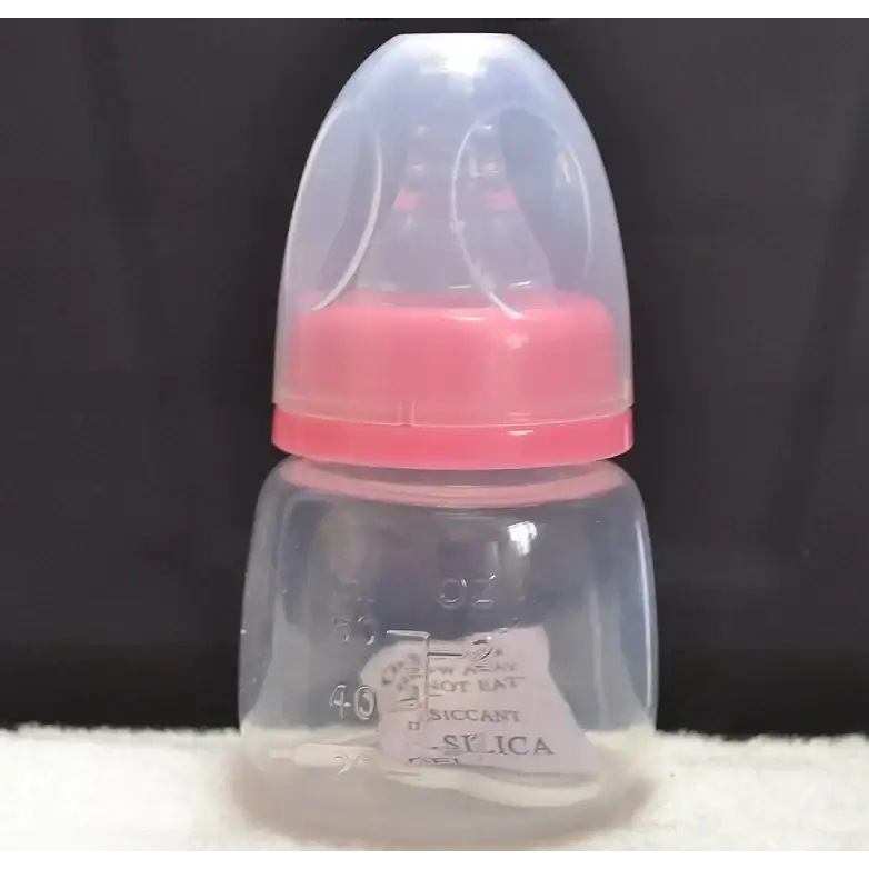 Clear plastic baby bottle with a pink silicone nipple and cap, featuring measurement markings on the side.