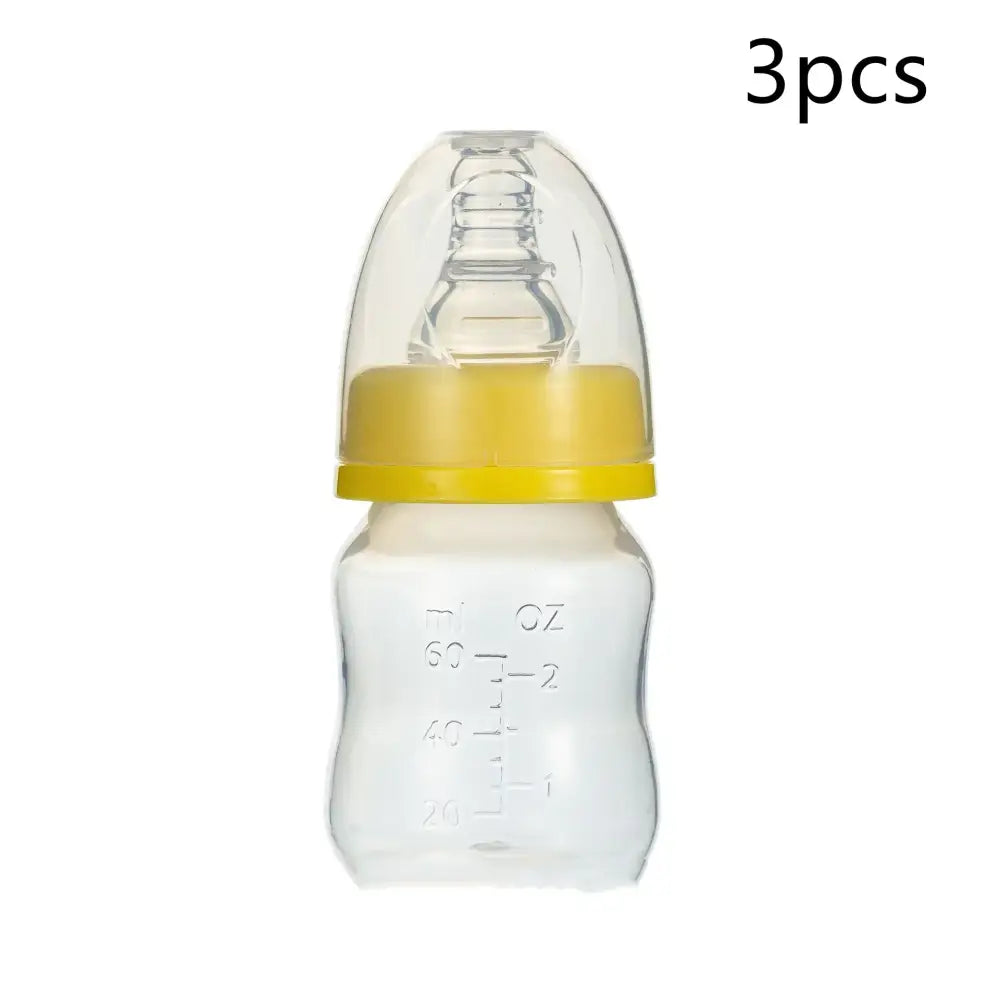 Clear glass baby bottle with a yellow plastic ring and transparent nipple, marked with ounce measurements.