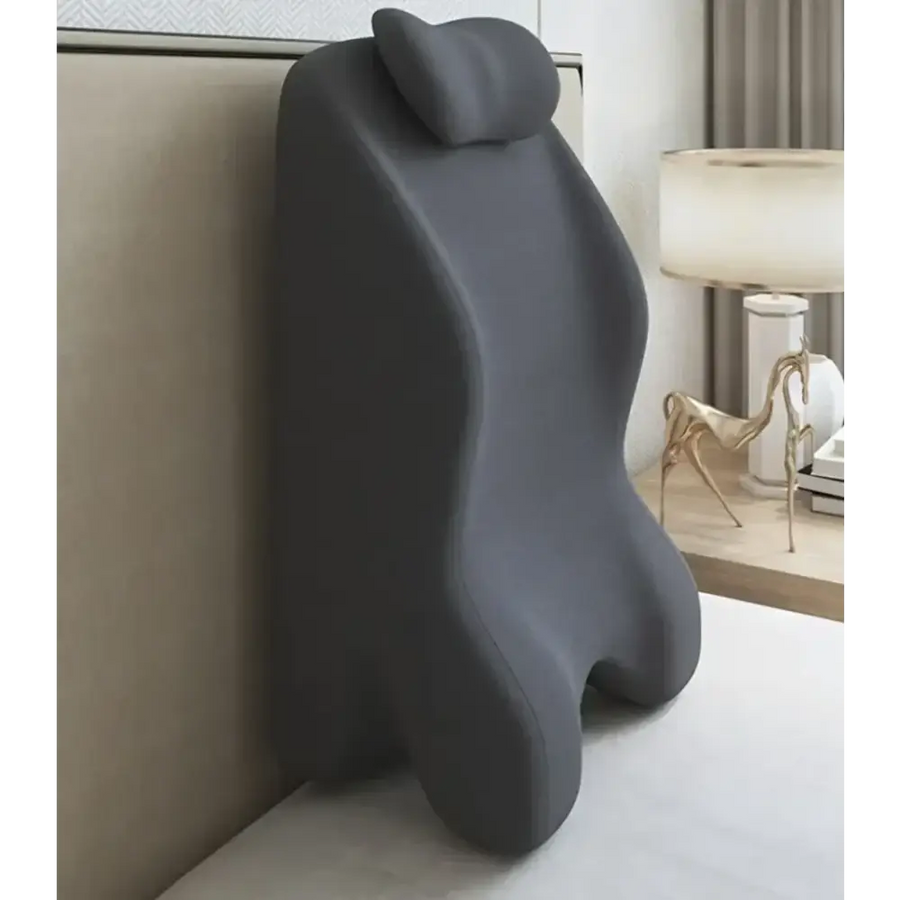 Dark gray ergonomic lumbar support pillow with contoured shape and soft, plush material.
