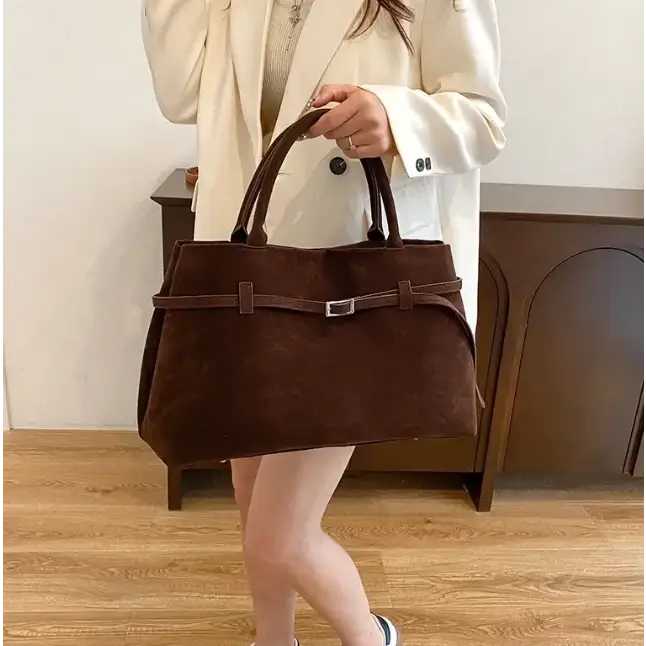 Brown suede tote bag with a silver buckle and matching handles.