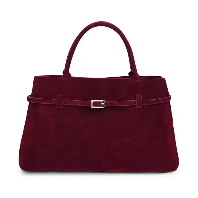 A burgundy suede handbag with a silver-toned buckle and matching handles.