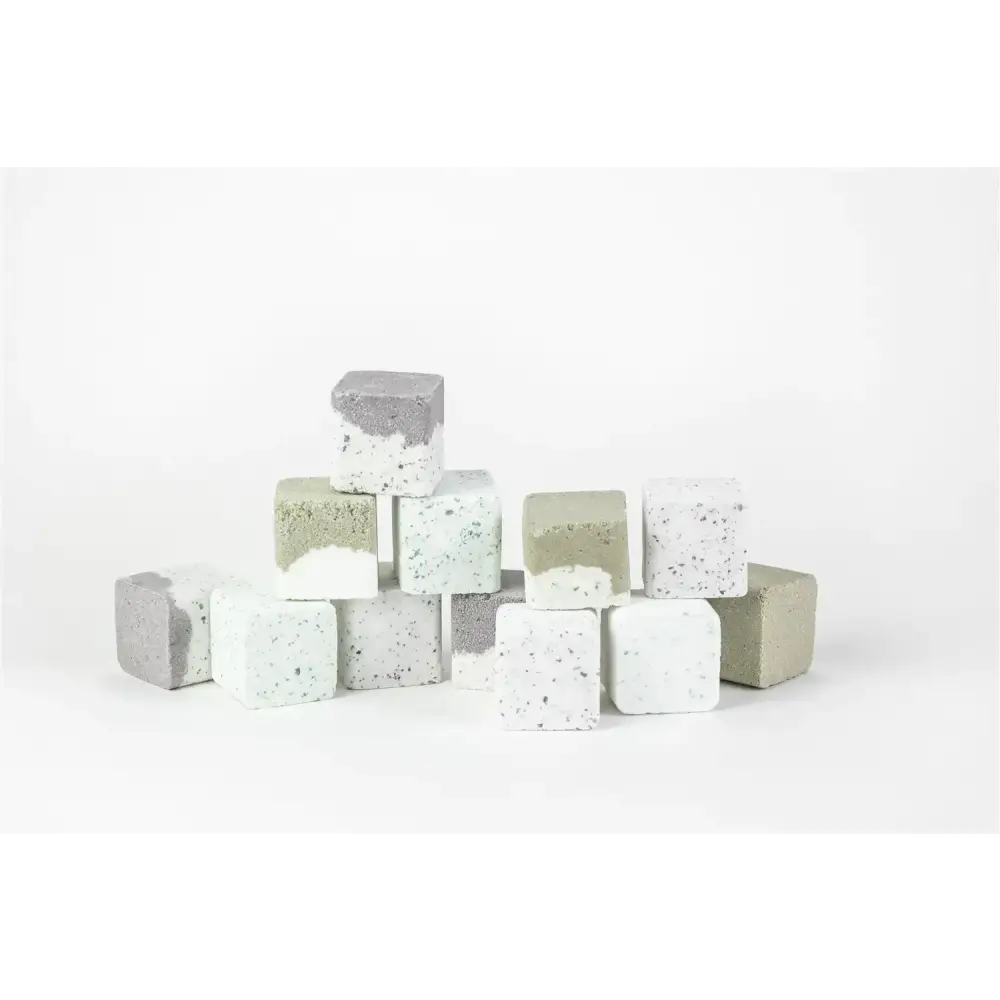 Concrete cubes in varying shades of gray, white, and light green with speckled textures.