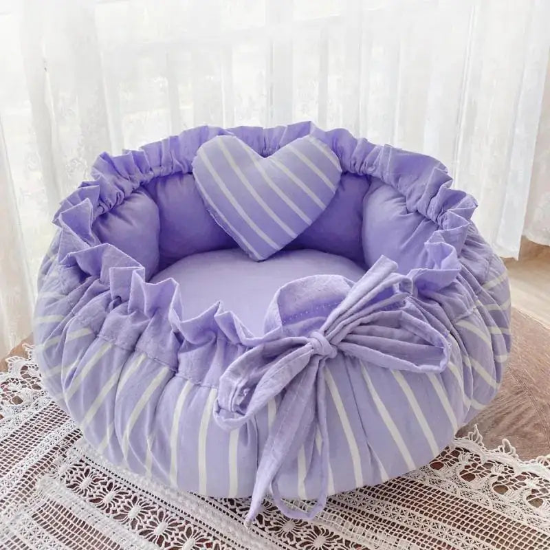Lavender and white striped plush pet bed with ruffled edges and a matching heart-shaped pillow.
