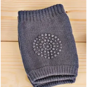 Dark gray knitted knee pad with a circular pattern of textured dots for grip.