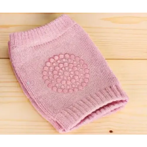 Pink knitted knee pad with a textured circular grip patch.