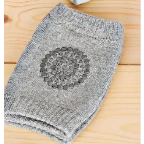 Gray knitted knee pad with a circular pattern of raised dots.