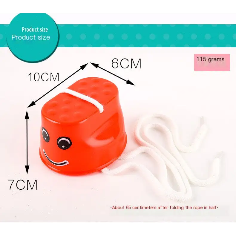 Bright orange plastic toddler step stool with a smiling face and white rope attached.