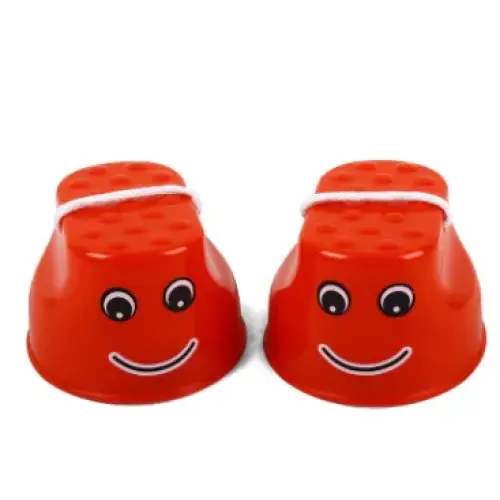 Red plastic footstools with smiling faces and googly eyes.