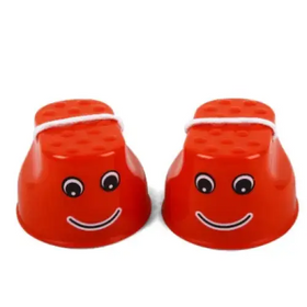 Red plastic footstools with smiling faces and googly eyes.
