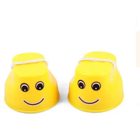 Bright yellow plastic cups with smiling face designs and white string tied around their tops.