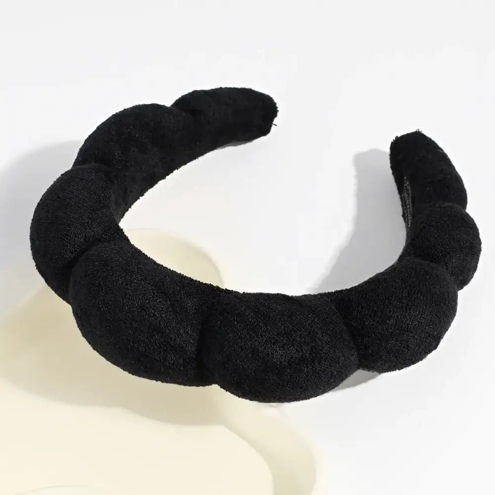 Black, plush-textured headband with a twisted, segmented design.