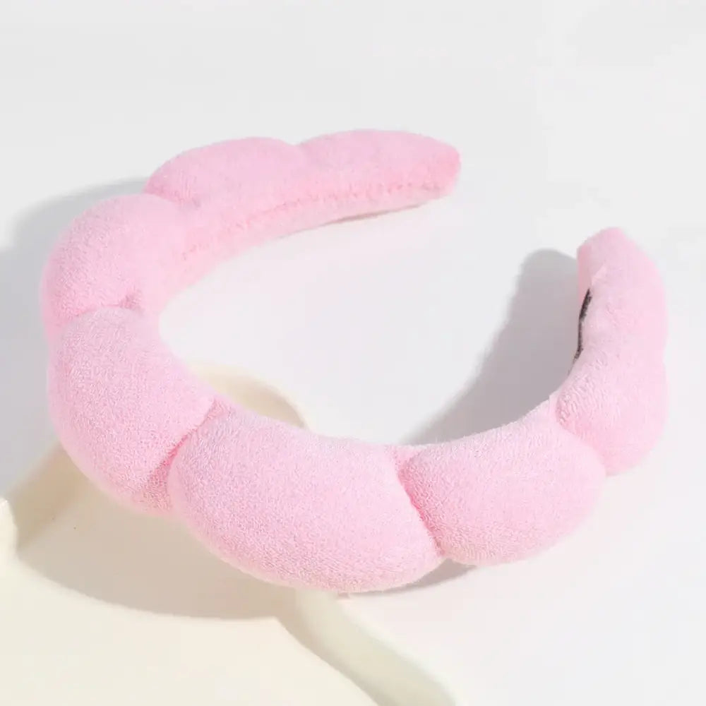 Pink, plush, segmented headband with a soft, fuzzy texture.