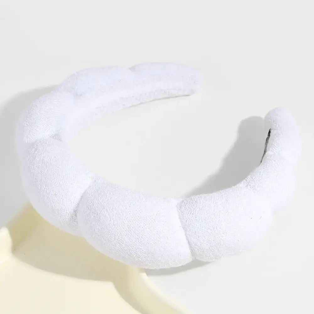 White, plush, segmented headband with a soft, textured fabric finish.