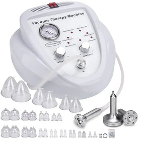 White plastic vacuum therapy machine with silver metallic knobs and a pressure gauge, accompanied by various clear glass cups and metal attachments.