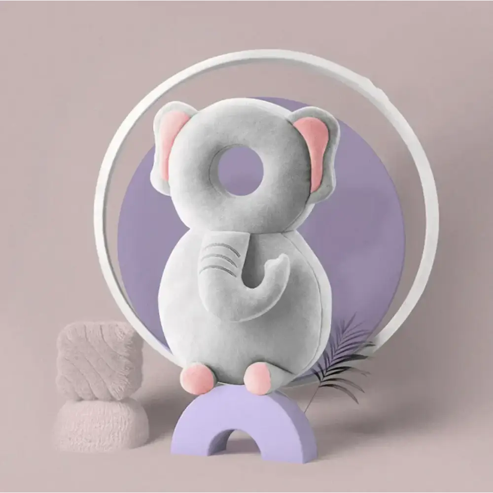 Soft gray plush elephant pillow with pink inner ears, feet, and a curled trunk.