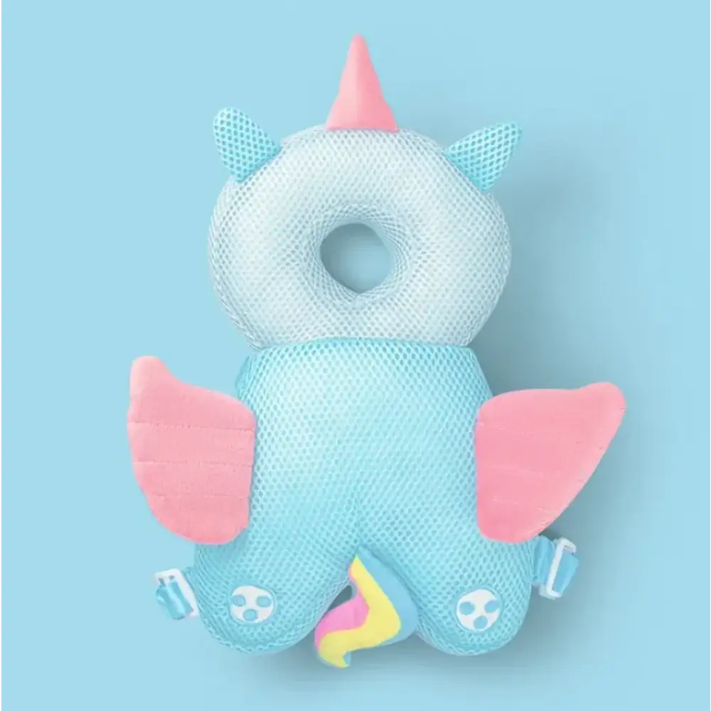 A soft, mesh unicorn-shaped baby head support with pink horns and wings, light blue body, and colorful rainbow tail.