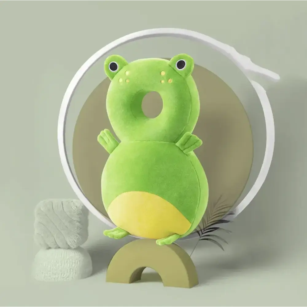 A plush green frog-shaped pillow with a yellow belly and black eyes, designed for comfort or decoration.