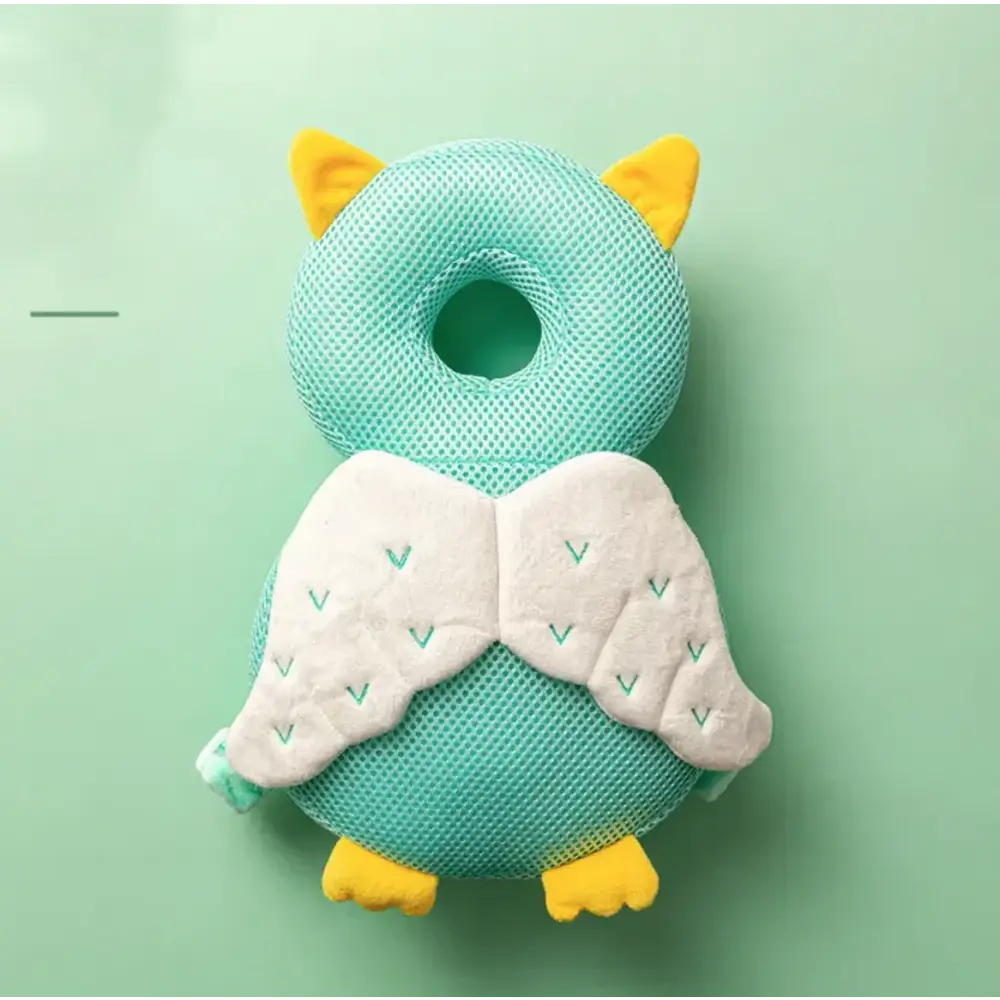 A mint green mesh owl-shaped baby head support with yellow ears, feet, and white wings embroidered with teal chevrons.