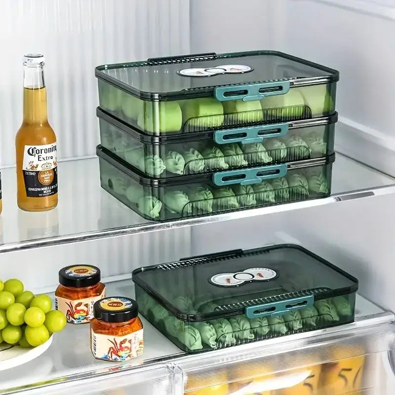 Stacked translucent green plastic food storage containers with teal-colored latches and black lids, each holding neatly arranged dumplings.