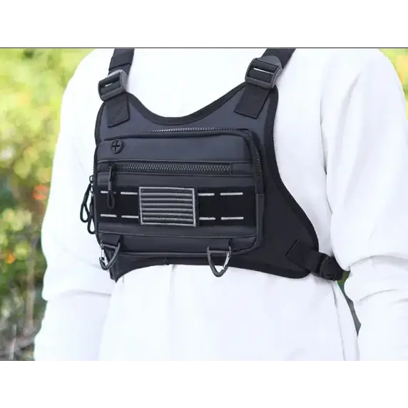 Black tactical chest harness with multiple zippered compartments and adjustable straps.