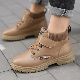 Tan faux leather ankle boots with a ribbed knit collar and velcro strap, featuring a chunky rubber sole.