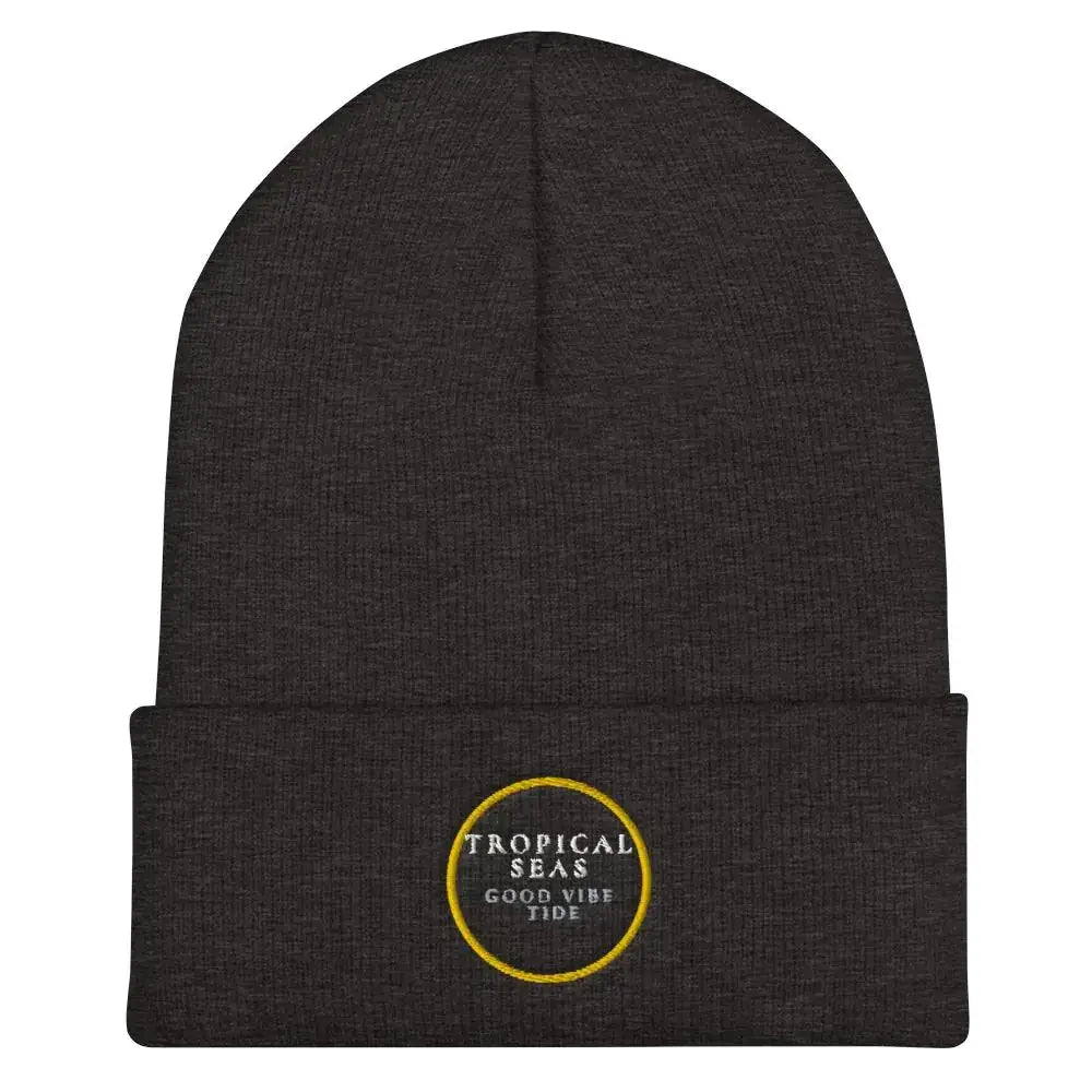 Dark heather gray knit beanie with a folded cuff and embroidered circular logo in yellow thread reading ’tropical seas good vibe tide’.