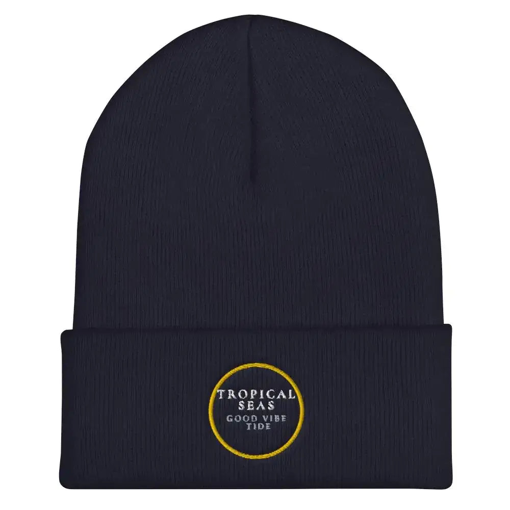 Navy blue knit beanie with a folded cuff and embroidered circular logo in gold thread reading ’tropical seas good vibe tide.’