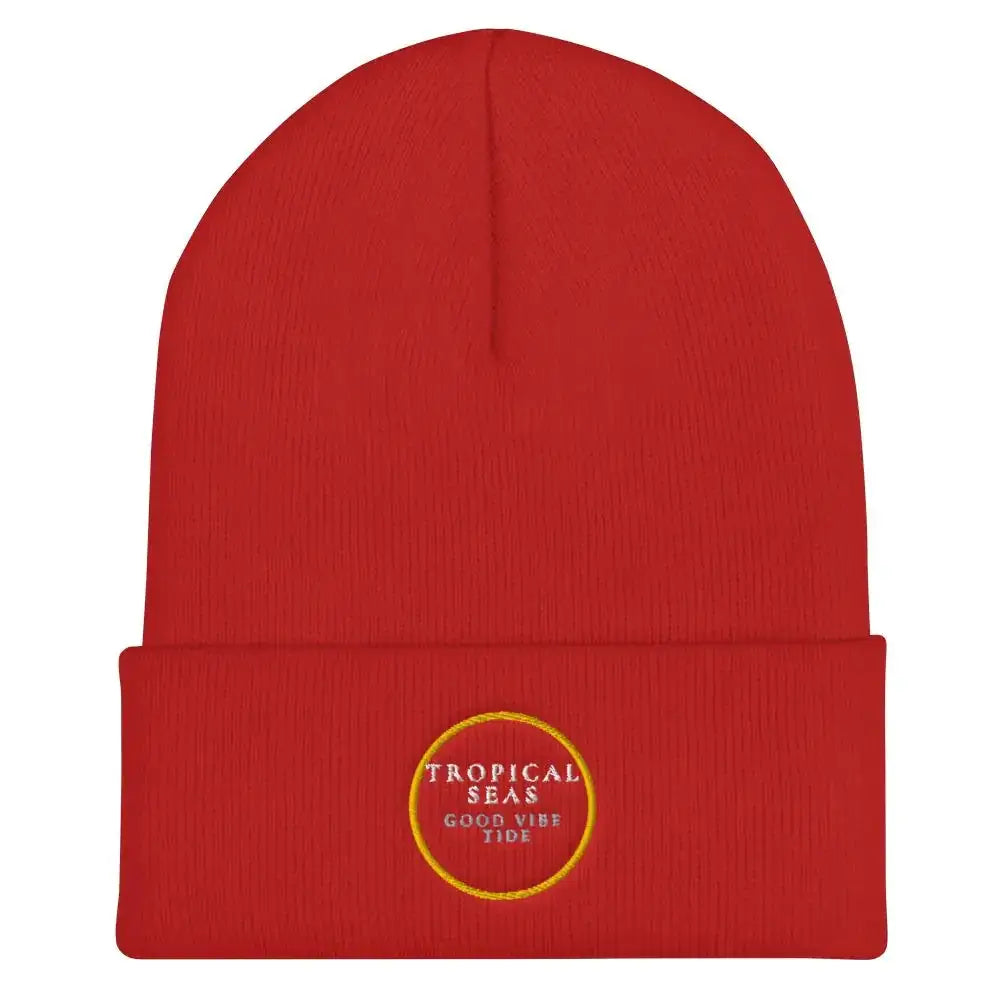 Red knit beanie with a folded cuff and embroidered circular logo reading ’tropical seas good vibe tide’ in white text outlined in gold.