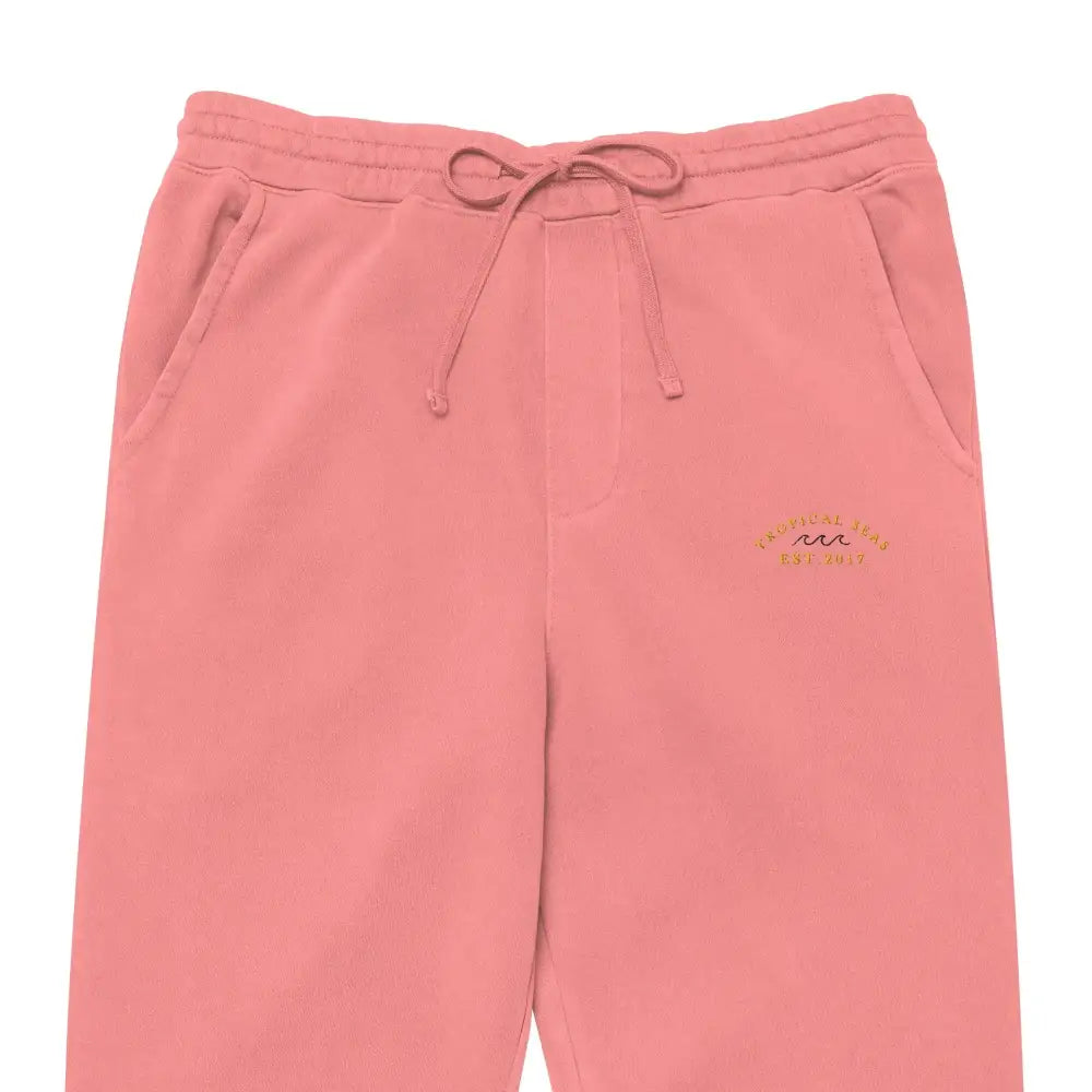Soft pink sweatpants with a drawstring waistband and embroidered logo on the thigh.