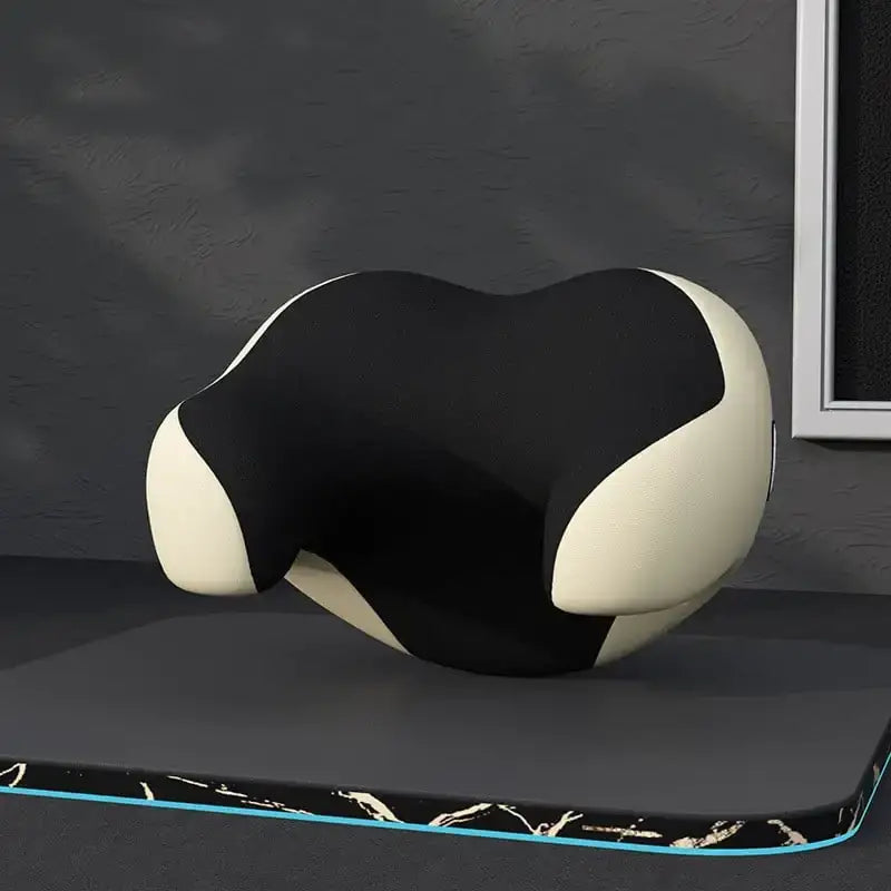 Black and white ergonomic neck pillow with a sleek, contoured design.