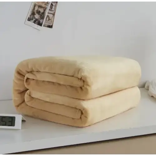 A plush, beige fleece blanket neatly folded into a compact stack.