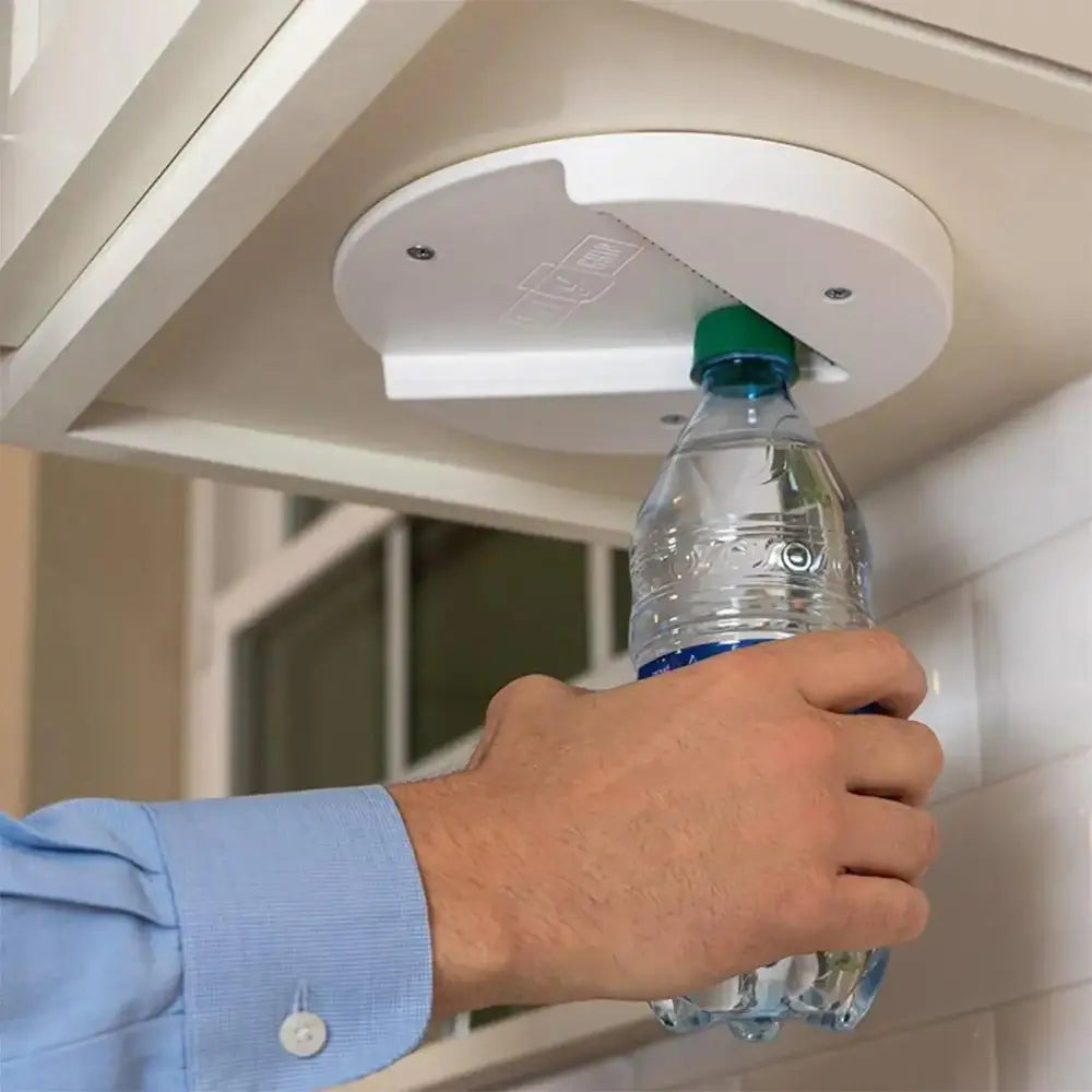 White circular can opener mounted under a cabinet, designed to open plastic water bottles with its integrated blade mechanism.