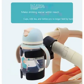 Light blue and black sippy cup with a cartoon unicorn design, attached to a stroller handle via a black clip.